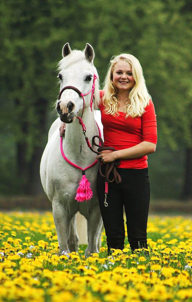 Meisje met pony in open veld met gele bloemetjes