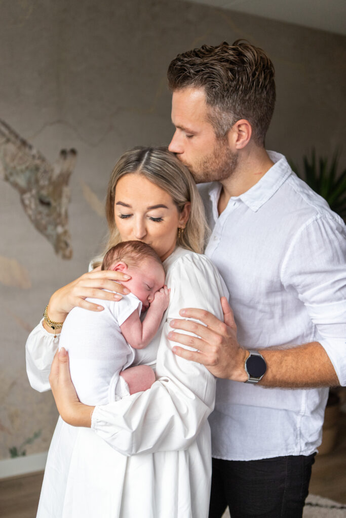 Familie fotoshoot met pasgeboren baby in de kinderkamer