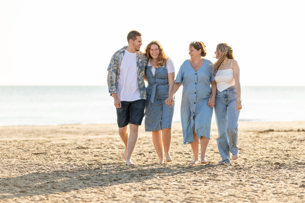 Moeder met drie kinderen op het strand