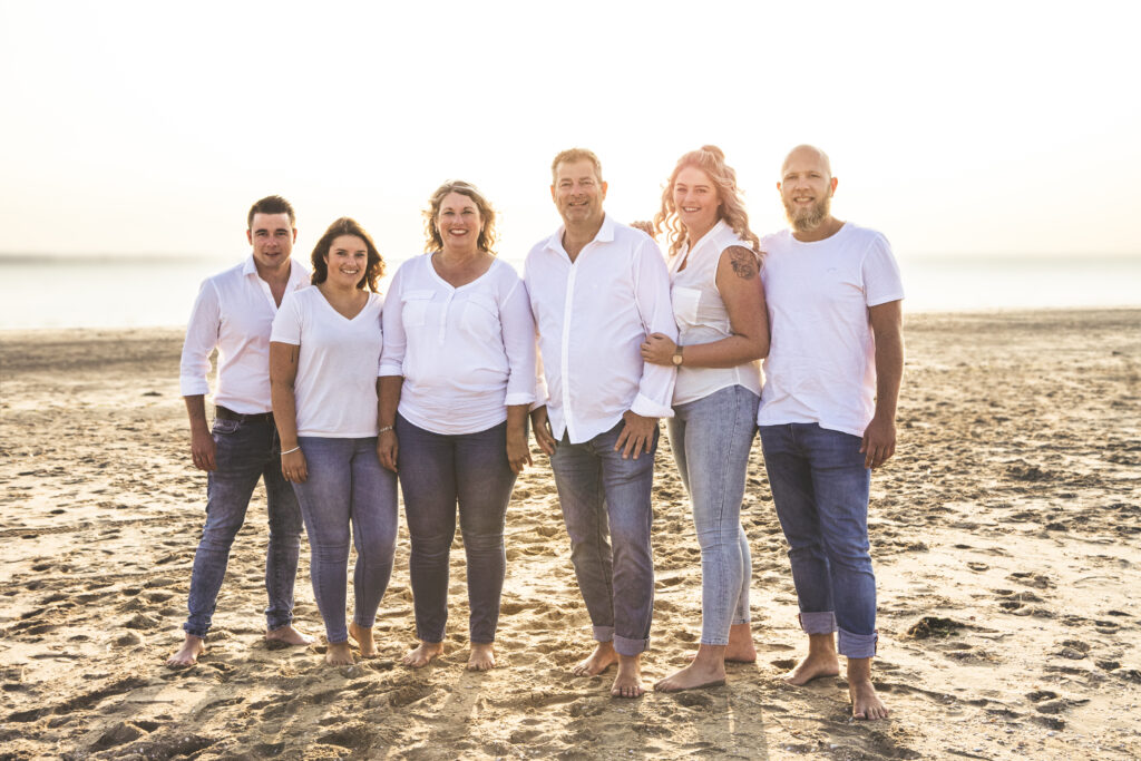 Familiefoto op het strand met witte kleding